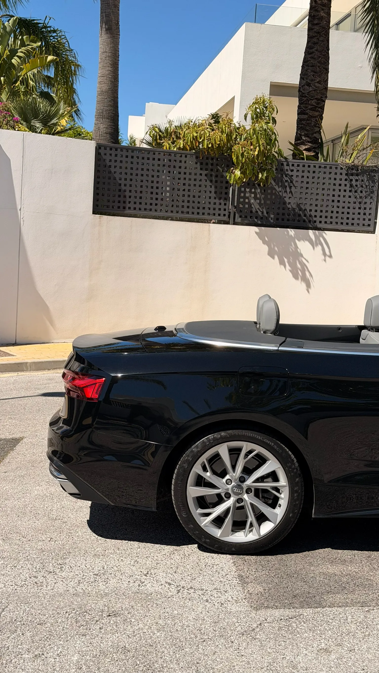 A5 Convertible rear detail with dynamic LED tail light, 5-spoke wheel and Mediterranean wall with palm trees