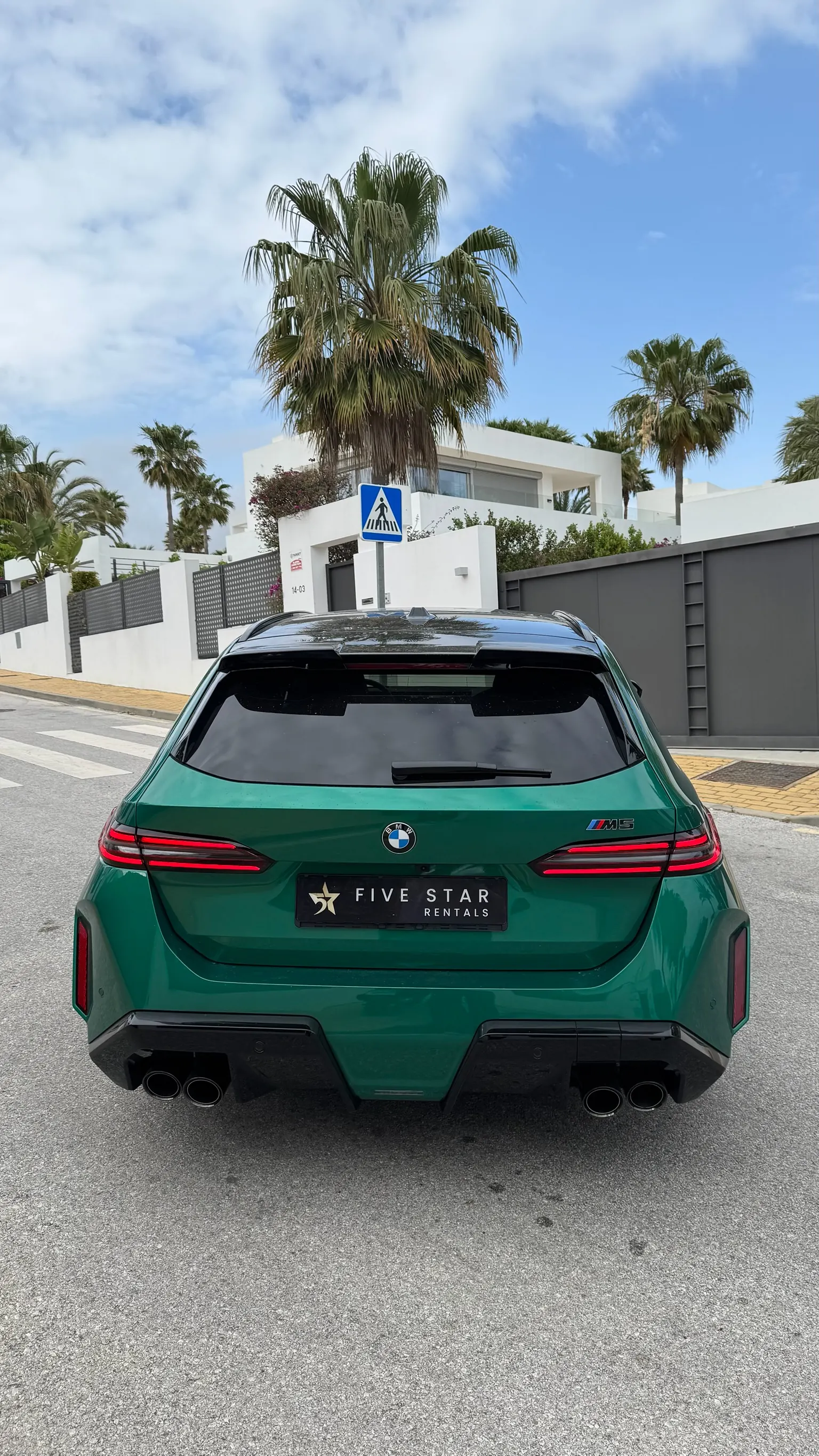 Full rear view of the BMW M5 Touring with quad M exhaust and Five Star Rentals plate