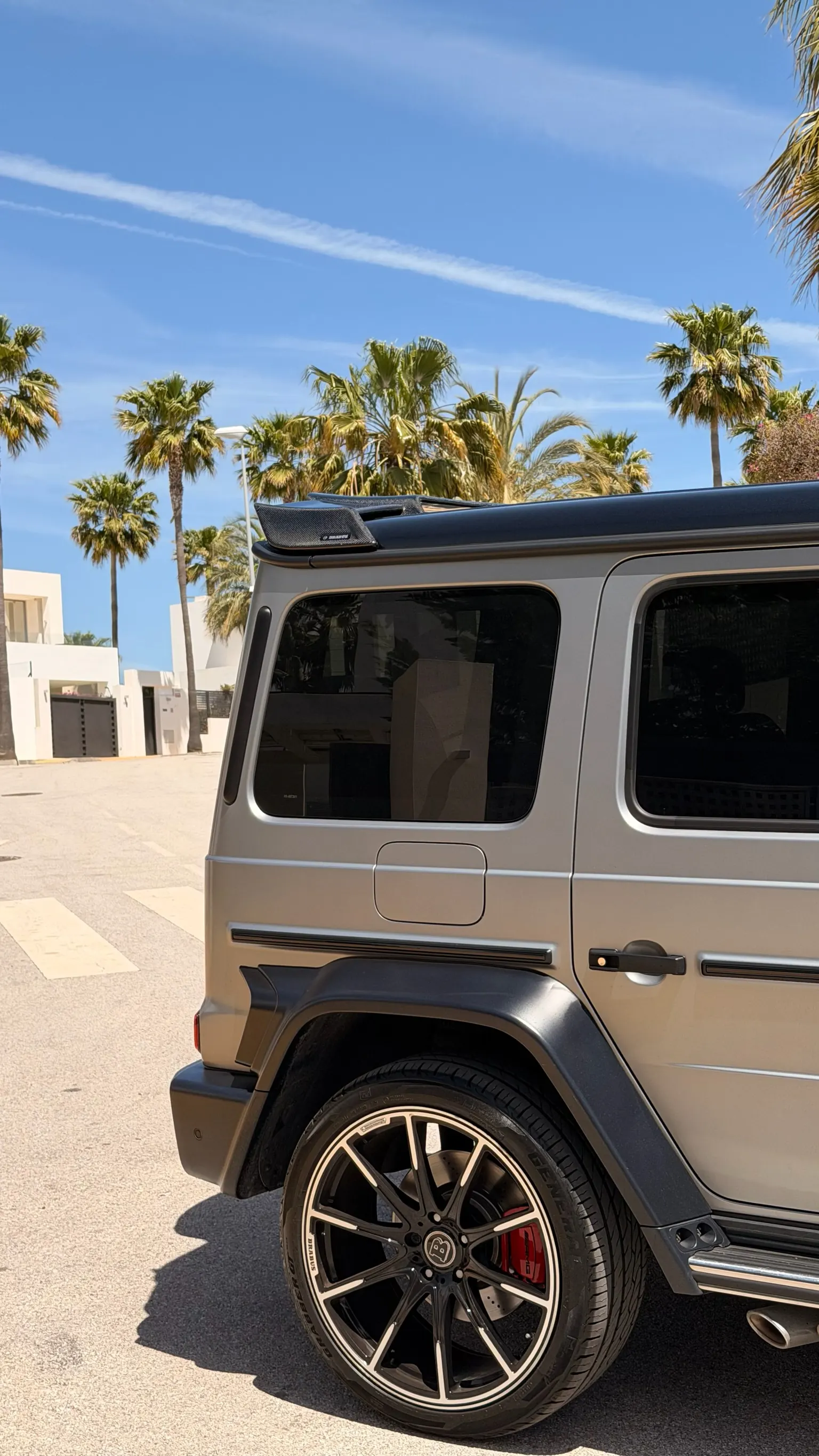 Close-up of 22-inch Brabus Monoblock wheel with red brake calipers and carbon spoiler