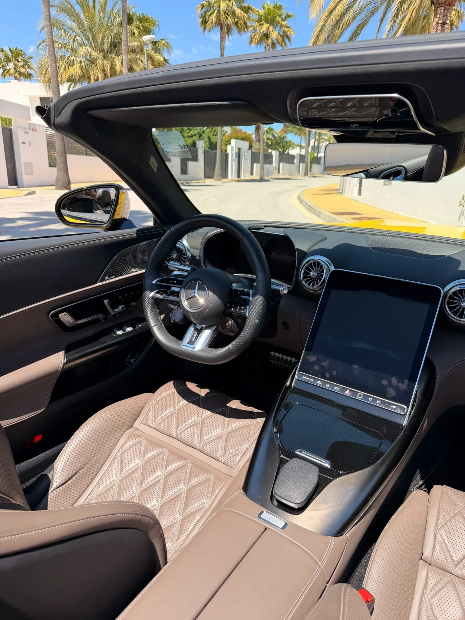 Mercedes-AMG SL 55 cockpit with 12.3-inch tilting portrait MBUX display, perforated leather AMG steering wheel and macchiato beige two-tone diamond-quilted seats