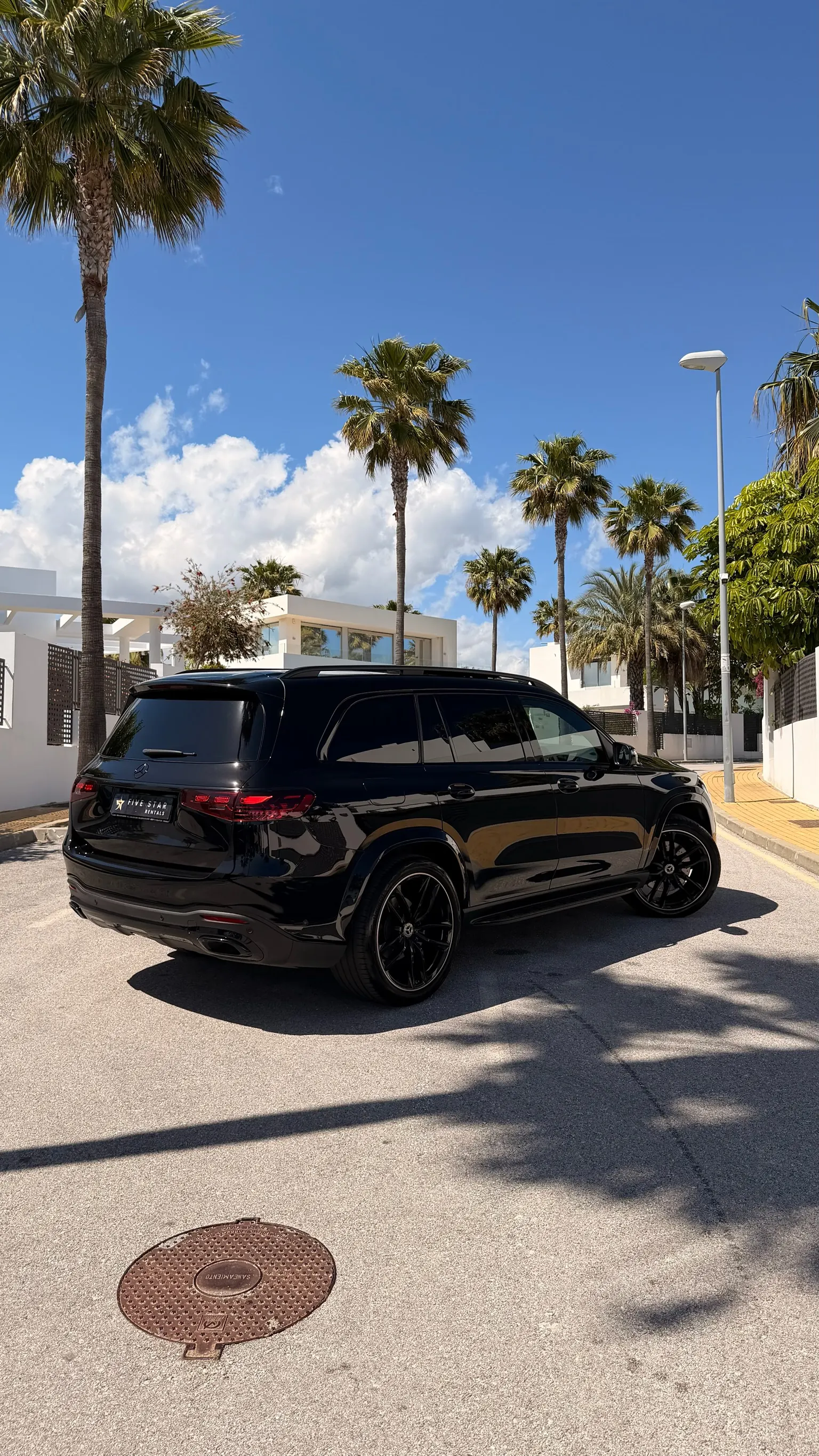 Centered rear view of the Mercedes-Benz GLS 580 4MATIC in Obsidian Black Metallic with Five Star Rentals plate, dual exhaust and LED tail lights
